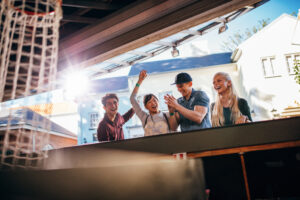 Young people playing basketball game at amusement park and having fun.